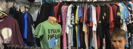 Ассортимент мужских футболок в магазине на рыночной аллее в Коблево